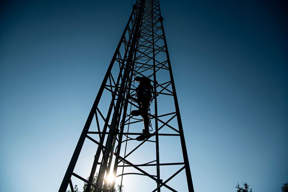 Tekniker i mast i aftensol