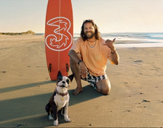 Surfer og 3hund på strand