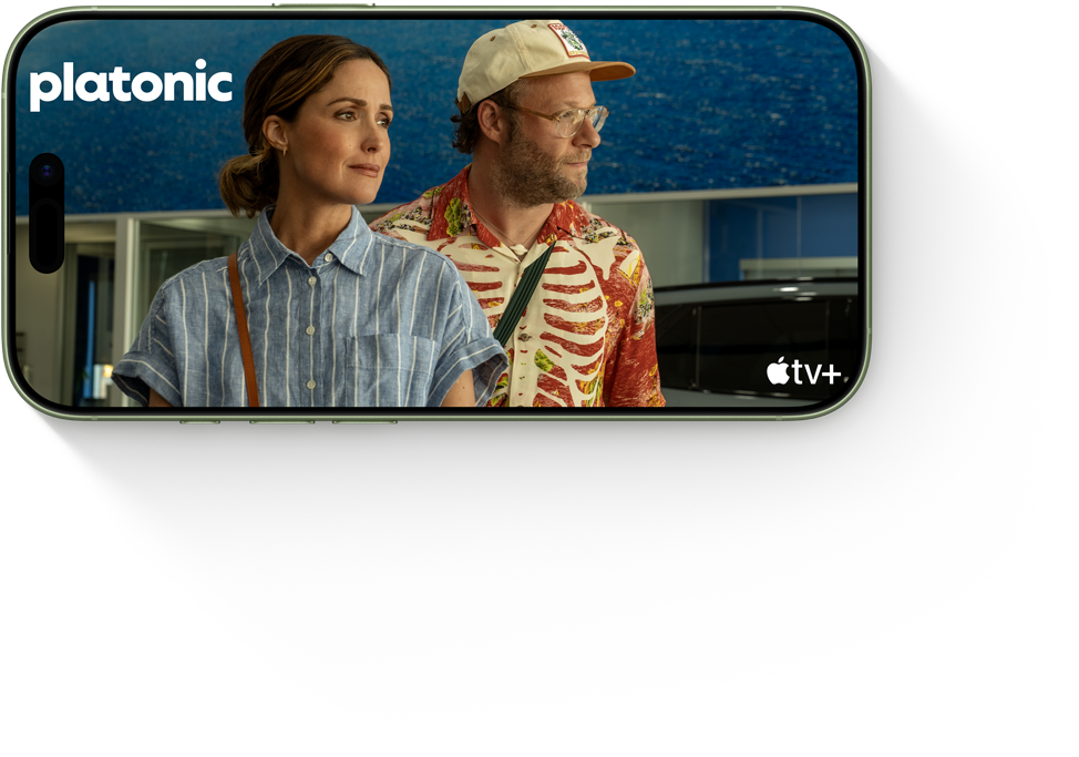 To personer i en scene fra serien "Platonic" på Apple TV+. En i blå skjorte og en i farverig tøj med kasket.