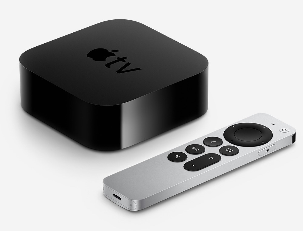 Sort Apple TV-boks med Apple-logo og sølvfarvet Siri Remote fjernbetjening på hvid baggrund.