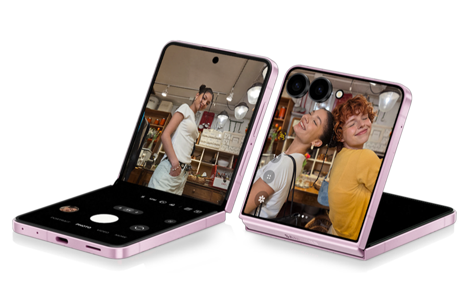 To foldbare smartphones i lyserød, der viser kamerafunktion med billeder af personer i en butik.