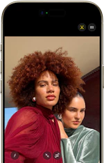 To personer med forskellig hårtype og tøj i røde og grønne nuancer, fotograferet på en smartphone-skærm.