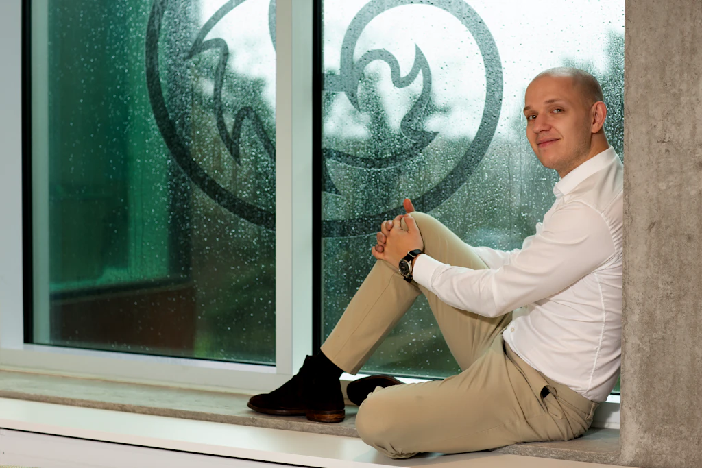 Om 3. Mød Theis Enø Larsen, Project Office Manager, siddende ved vindue med 3-logo.